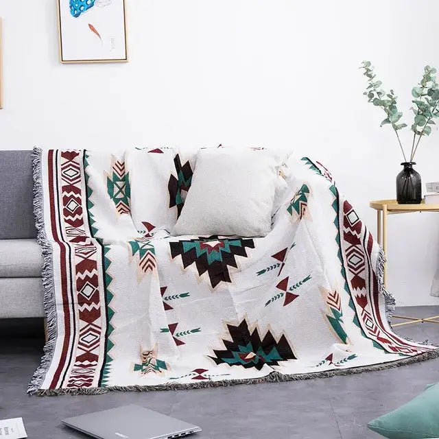 White sofa blanket with geometric dustproof butterfly carp pattern in maroon teal and black with fringed edges