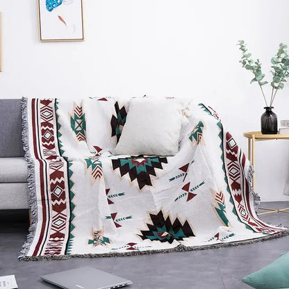 White sofa blanket with geometric dustproof butterfly carp pattern in maroon teal and black with fringed edges