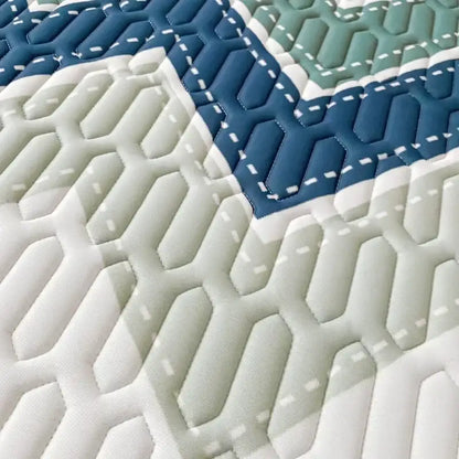Quilted mattress topper with geometric hexagonal pattern in white navy blue and sage green for decorbites cool summer blanket set