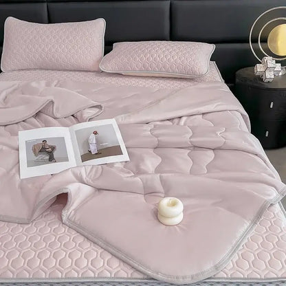 Soft blush pink quilted bed set with hexagonal stitching and matching pillows as decorbites cool summer blanket set