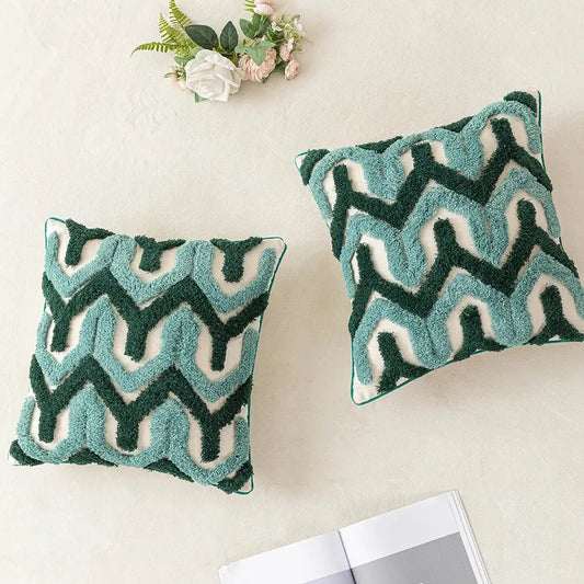 Two square pillow covers with plush teal and dark green embroidered zigzag pattern on cream for decorbites boho tufted decor