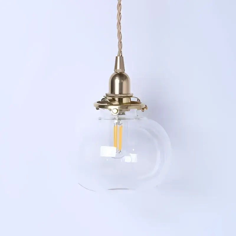 Teal glass ball pendant light with brass hardware featuring a clear glass globe and exposed led filament bulb decorbites glass ball