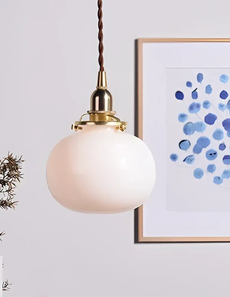 Soft pink rounded glass ball pendant light with brass hardware and twisted brown cord for bedroom decorbites glass ball