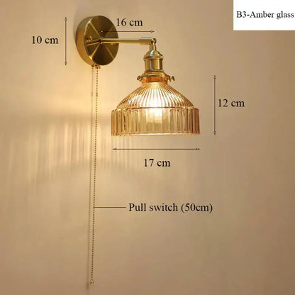 Vintage-style brass wall lamp with ribbed amber glass shade and pull chain switch for luxury living room decor