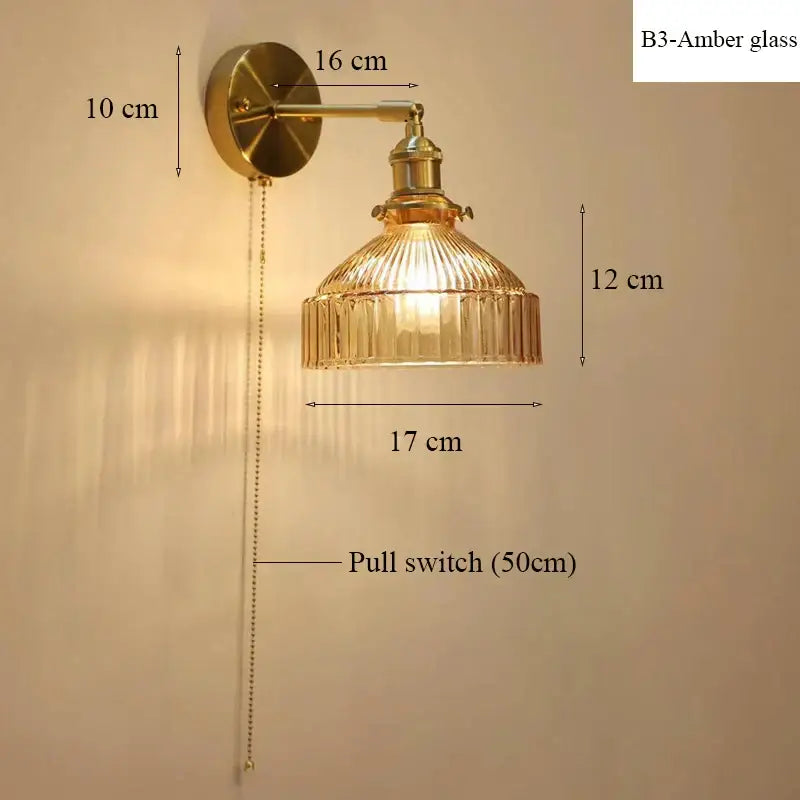 Vintage-style brass wall lamp with ribbed amber glass shade and pull chain switch for luxury living room decor