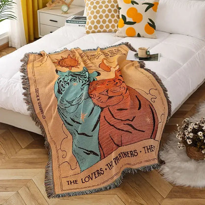 A beige decorbites knitted nordic outdoor sofa throw with teal and orange tigers under a sun motif labeled the lovers
