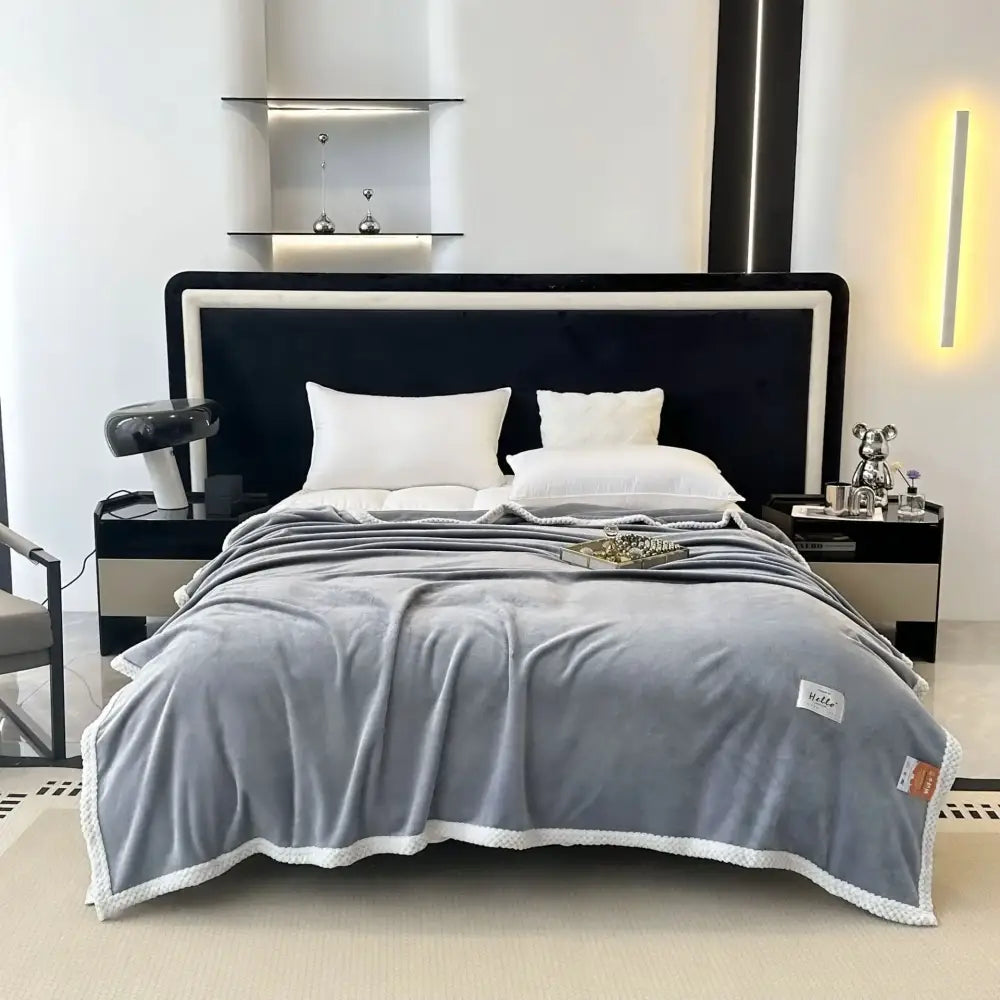 Gray plush throw blanket with soft velvety texture and white trim perfect for a cozy flannel nap or flannel nap blanket use