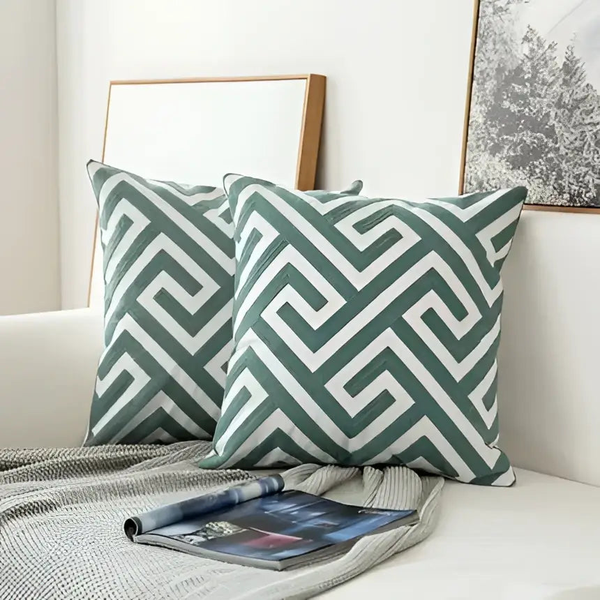 Teal and white embroidered geometric floral cushion cover with green and white geometric patterned throw pillows for living room