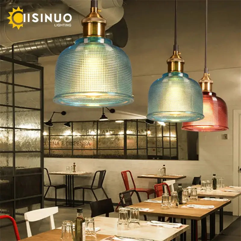 Blue and red textured glass pendant lights with brass fixtures in a dining room set featuring glass pendant lighting