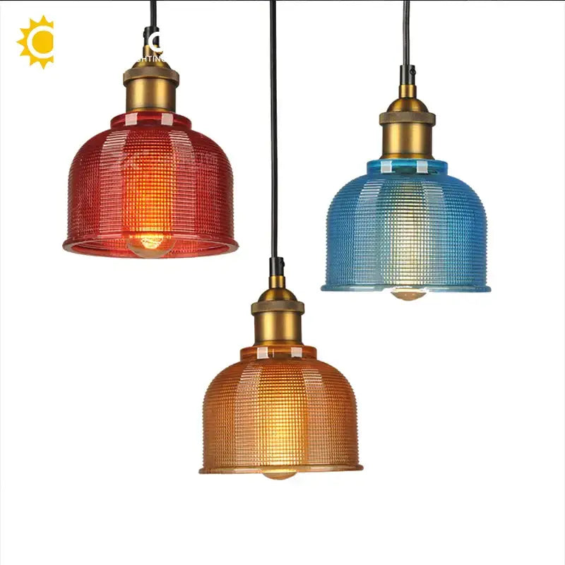 Three vintage-style glass pendant lights with textured red blue and amber shades and brass fixtures for dining room use