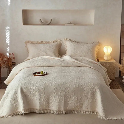 Cream-colored decorbites cotton quilted bedspread set with intricate swirling patterns and fringed edges for bedroom decor