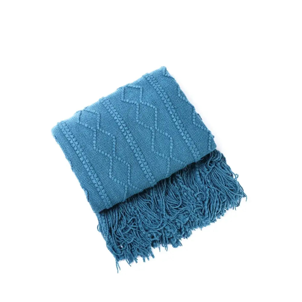 Teal blue knit throw blanket with diamond pattern and fringed edges perfect for cozy knit decorbites living room use