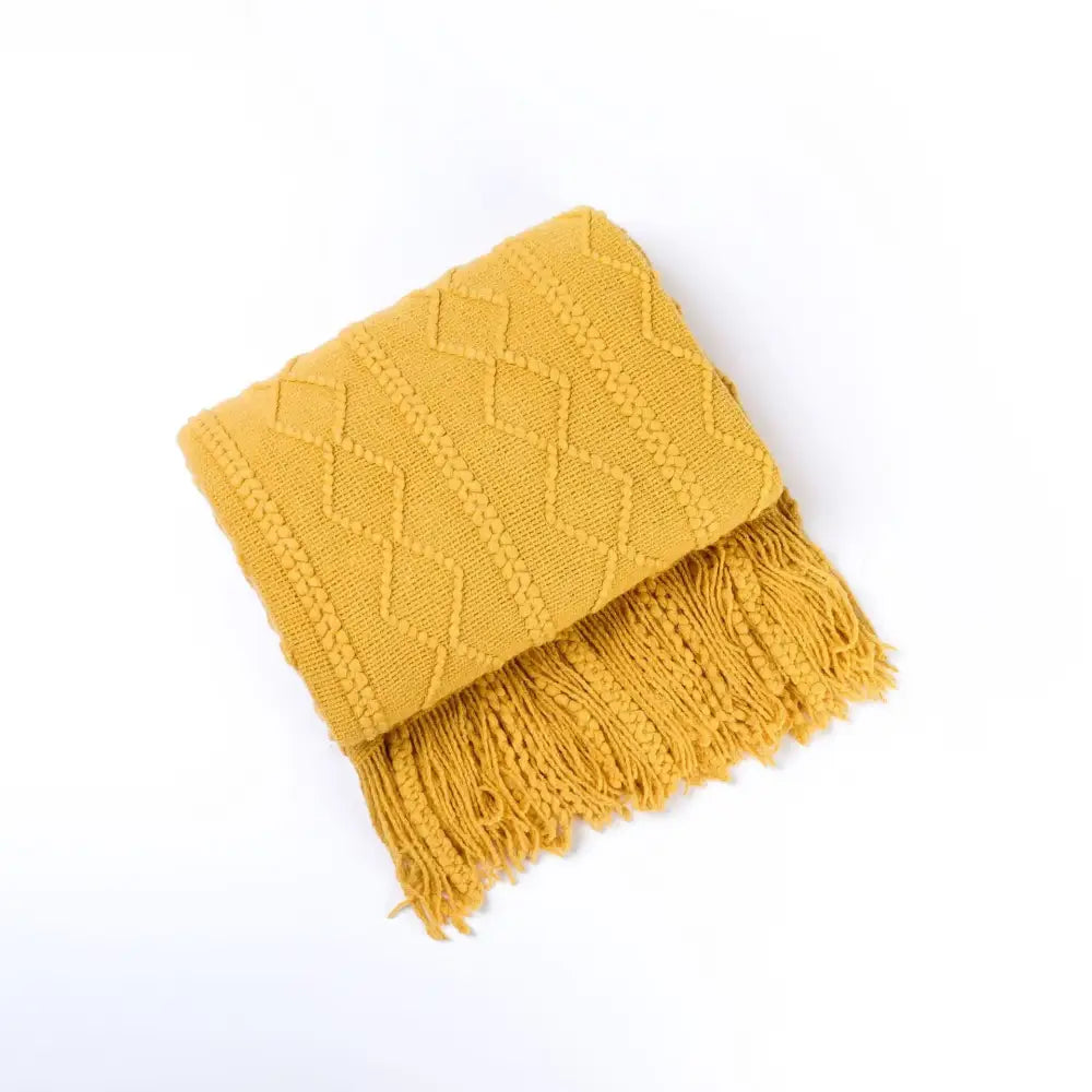Cozy knit throw blanket in mustard yellow with textured diamond pattern and tassels for decorbites cozy knit living room decor