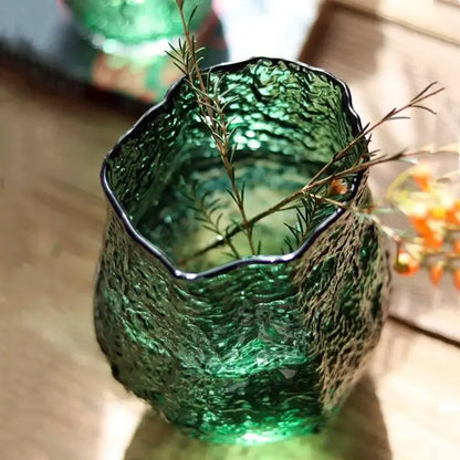 Textured frosted green transparent glass vase with a black rim holding rosemary sprigs for living room decorbites decor
