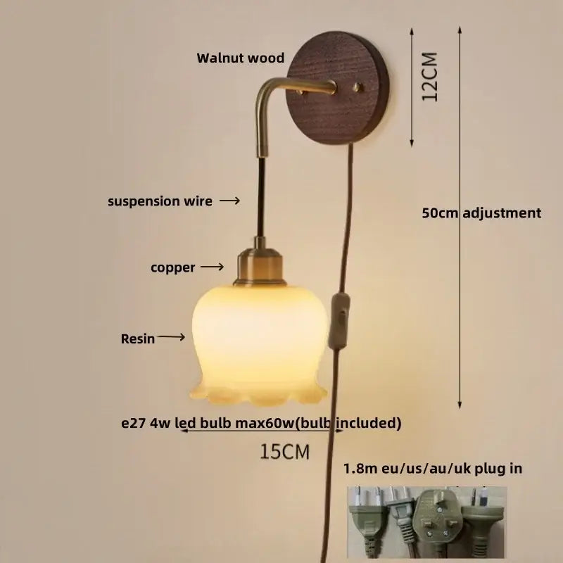 A warm glowing decorbites adjustable led wall light with textured glass shade brass accents on walnut wood plate