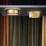 Two circular ceiling lights with a textured gold shade and pleated off-white glass shade for bedroom use