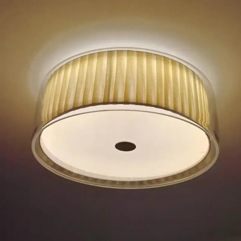A warm-toned ceiling light with a pleated beige fabric shade and metallic rim for bedroom use ceiling lamp
