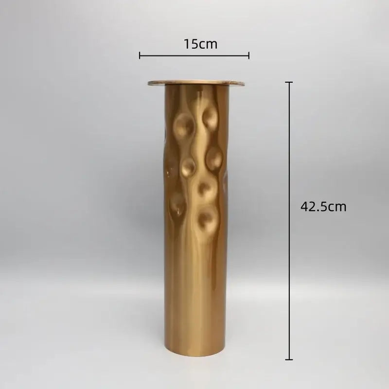 A tall cylindrical brass golden metal candlestick holder with hammered texture for decorbites dining room decor