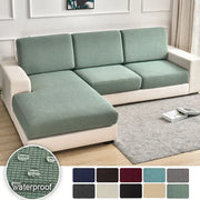 A textured green waterproof elastic sofa cover with a stretchy finish for living room slipcover use