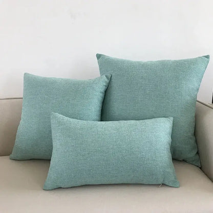 Set of three teal linen throw pillows in varying sizes on beige decorbites ivory sofa with ivory sofa cushion cover