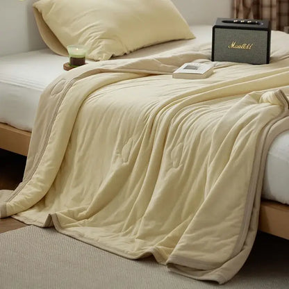 Cream-colored decorbites cotton summer comforter with plush quilted texture and subtle stitched patterns for cooling bedroom use