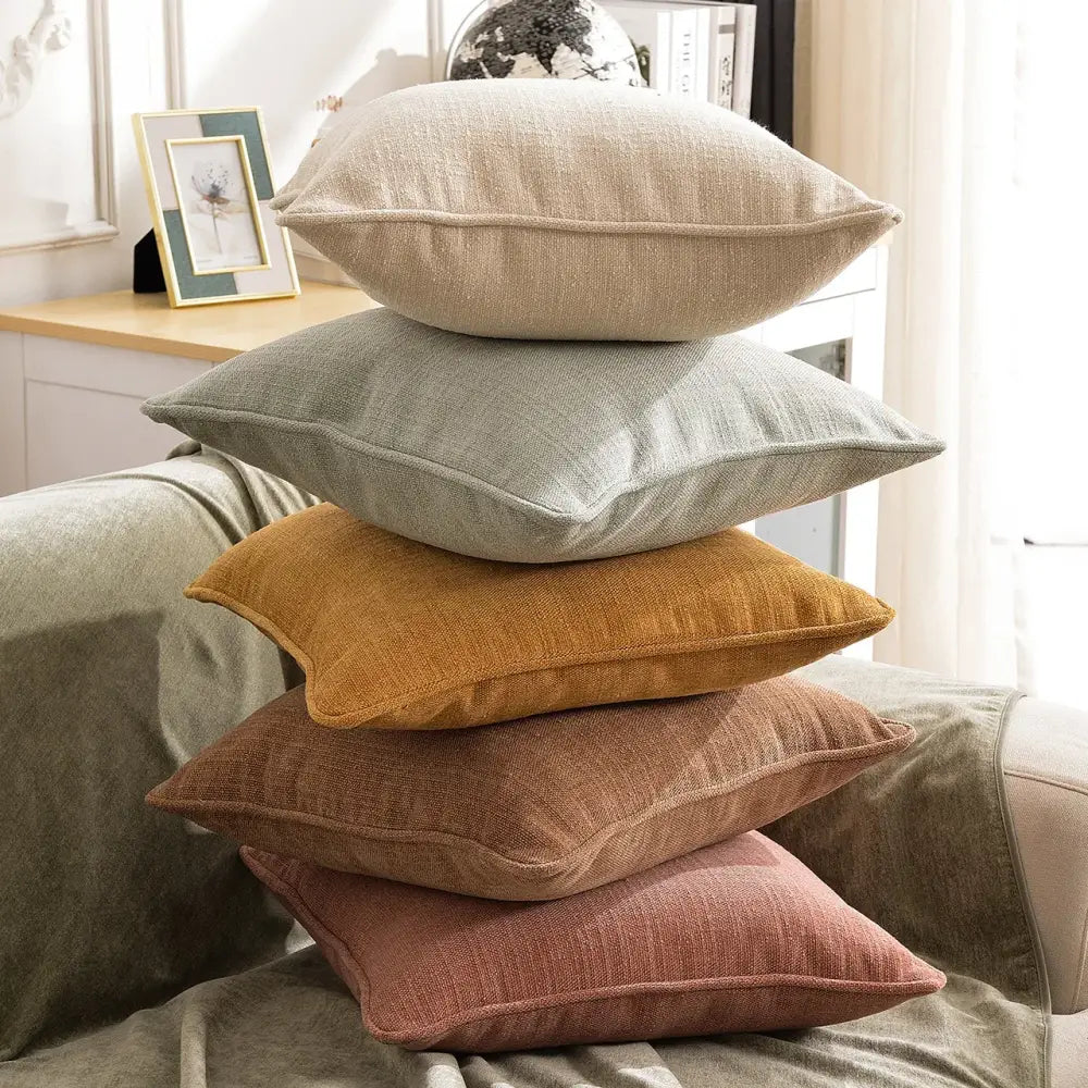 Stack of five peach and grey textured cotton linen pillow covers with visible weave and stitched edges for living room decorbites cotton linen
