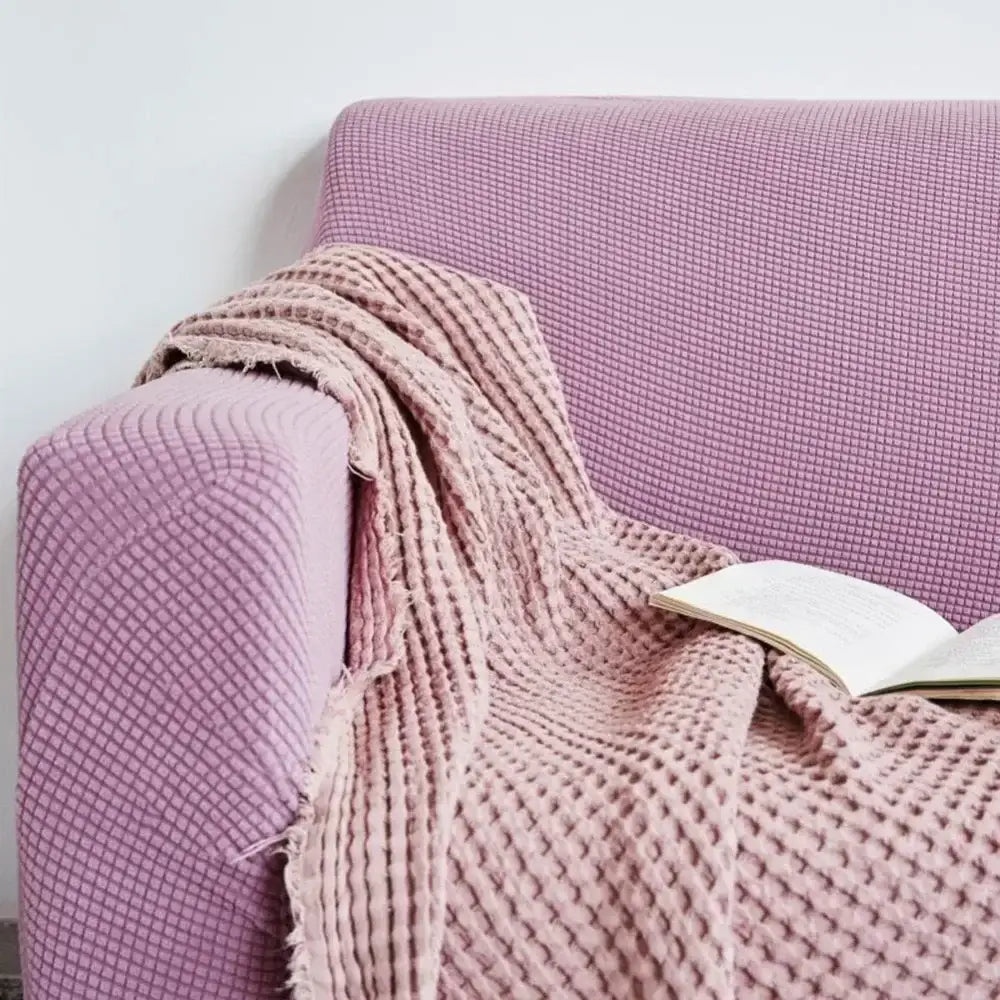 Pink waffle knit blanket draped over lavender cozy fleece sofa slipcover by decorbites for living room decor
