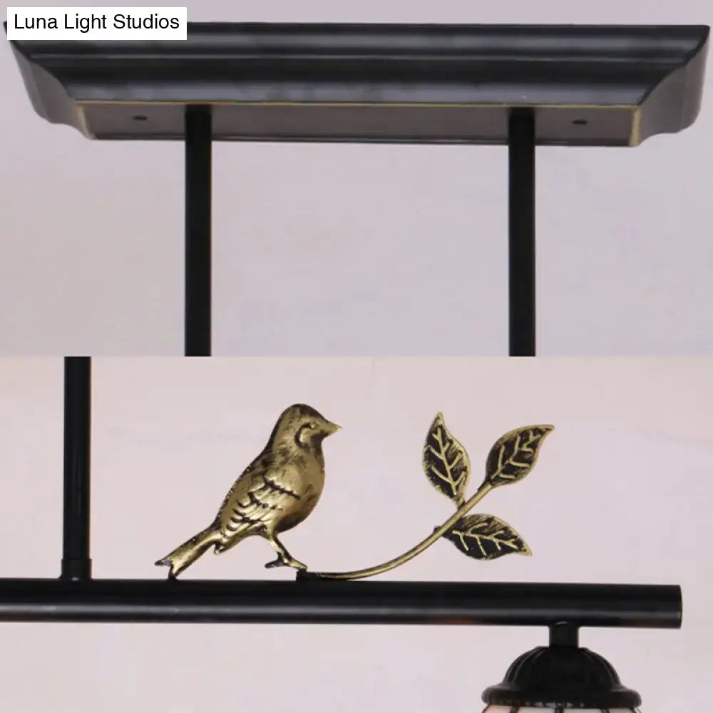 Gold-toned bird ornament on leafy branch detail of DecorBites™ Tiffany style black antique brass pendant light chandelier