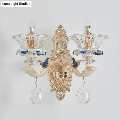 Traditional brass wall sconce light with gold finish, crystal flower-shaped shades, blue accents for living room use