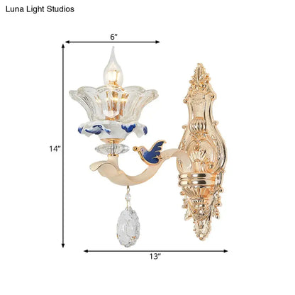 Traditional brass wall sconce light with gold finish, clear flower glass shade, blue enamel, and crystal teardrop for living room