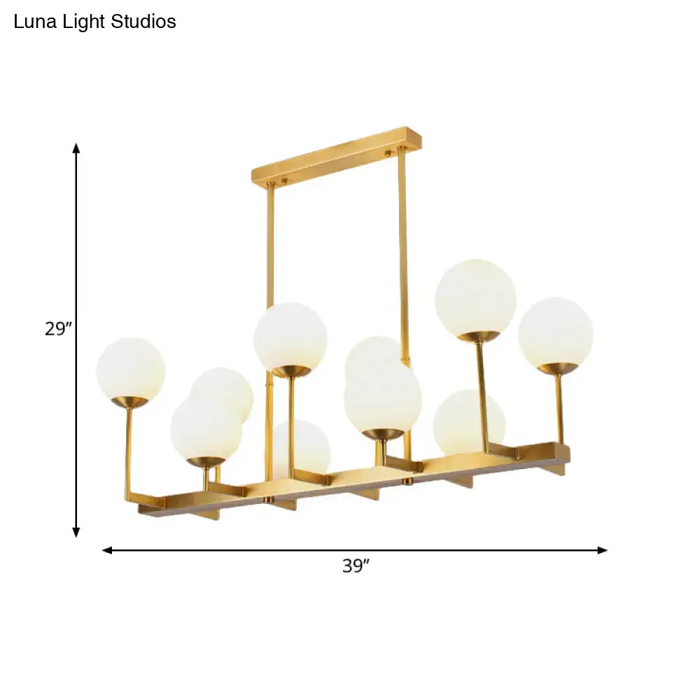 Gold-toned DecorBites™ opal glass island pendant light with frosted globe shades for traditional dining rooms