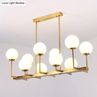 Gold-toned DecorBites opal glass island pendant light with 10 frosted globe bulbs for traditional dining room use