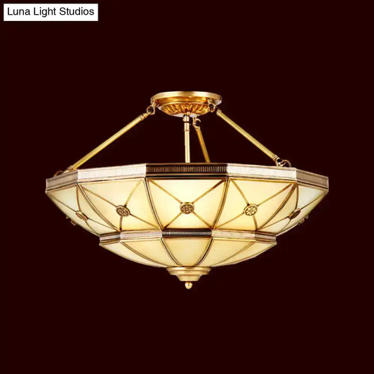 Gold-toned semi-flush mount fixture with geometric stained glass and brass accents 23.5 to 32 inch width 220v-240v