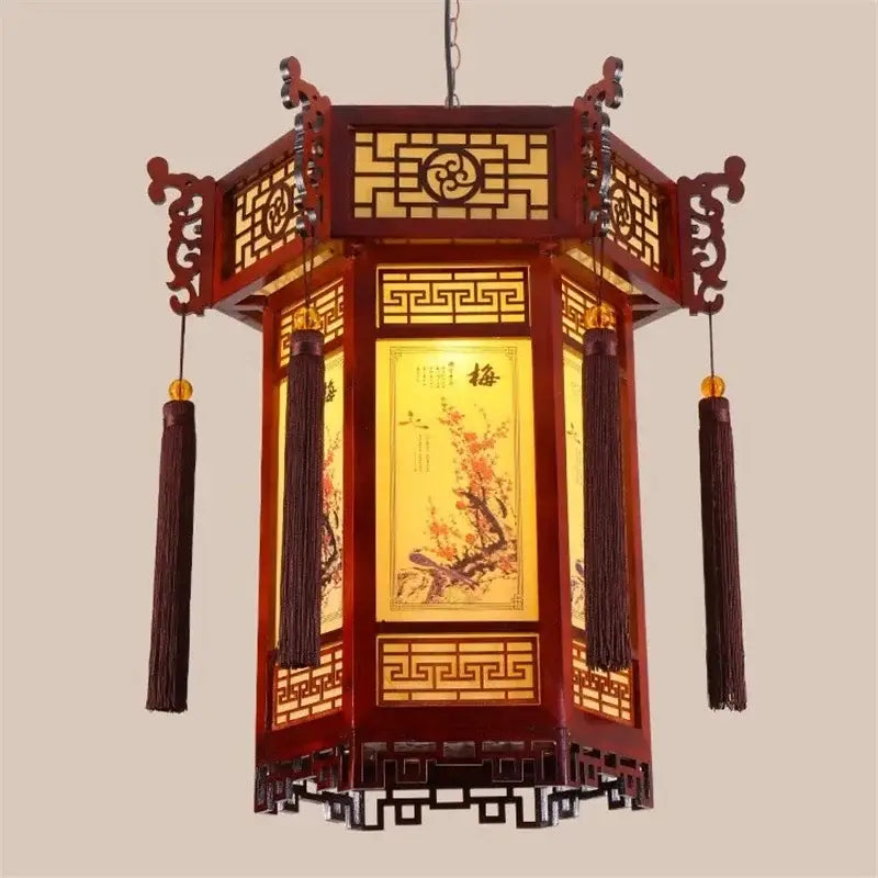 Red wooden bamboo lantern pendant lights with intricate lattice work golden accents and dark tassels for dining room