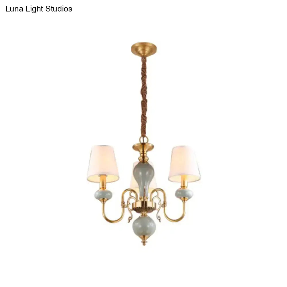 Traditional gold and blue chandelier with ceramic orbs and shades suspended by twisted rope for dining room lighting