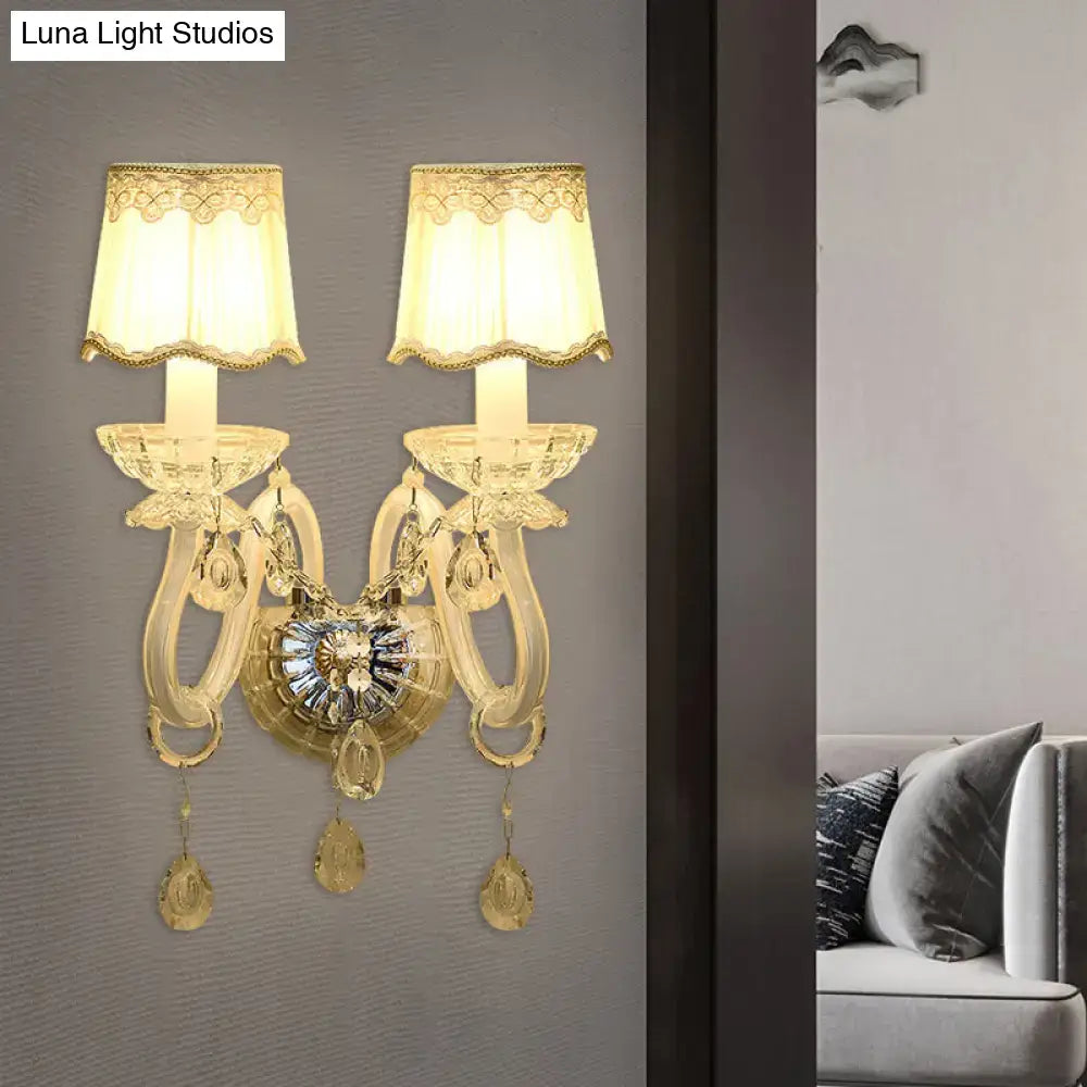Traditional gold crystal candle wall lamp with two cream lace-trimmed shades and dangling teardrop crystals