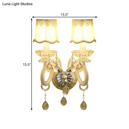 Traditional gold crystal candle wall lamp with ornate design cream lace shade and dangling teardrop pendants for bedroom