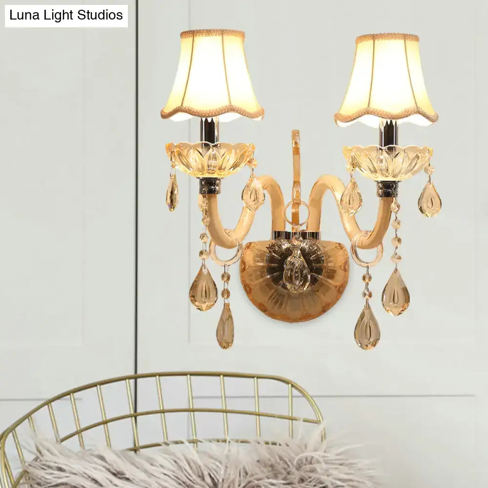 Traditional gold crystal wall sconce featuring fabric shade and teardrop crystals for bedroom lighting