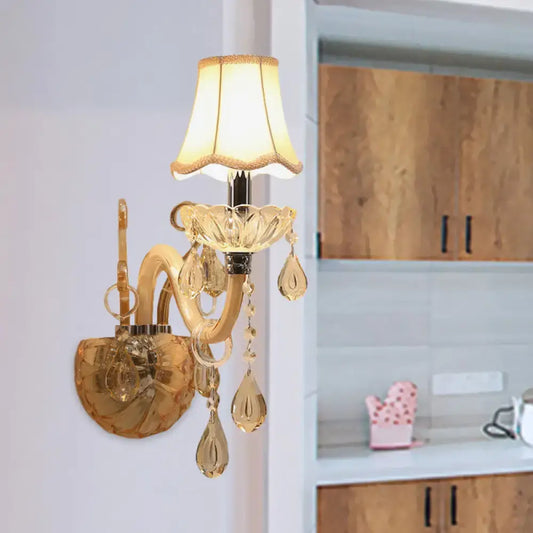 Traditional gold crystal wall sconce with fabric shade featuring warm illumination and dangling teardrop crystals