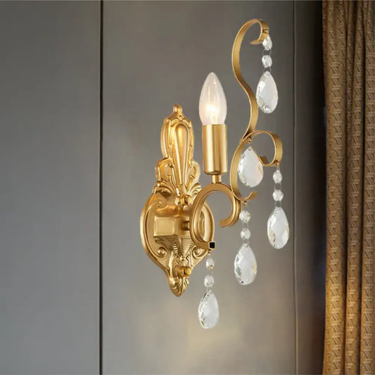 Traditional gold metal candle wall lamp with ornate design and dangling crystal teardrops for living room use