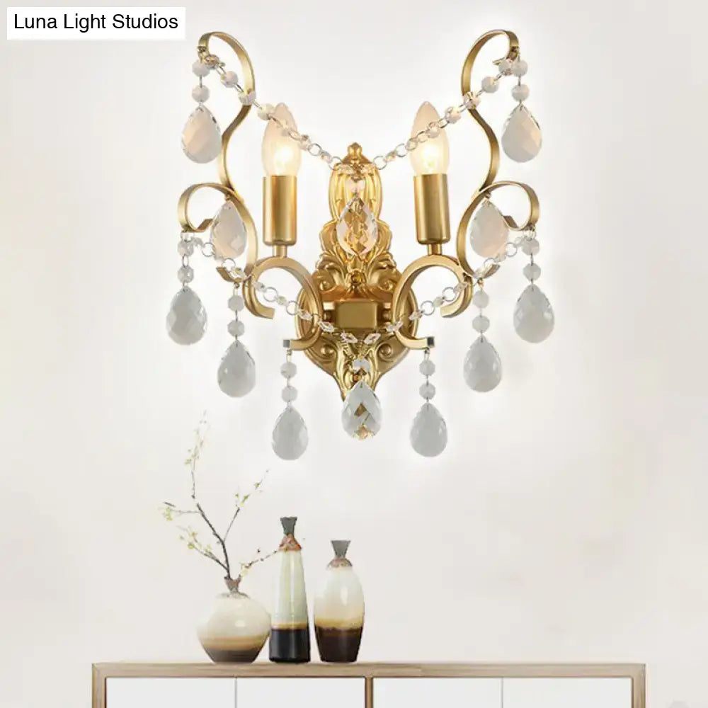 Traditional gold metal candle wall lamp with ornate design and dangling teardrop crystal pendants for living room use