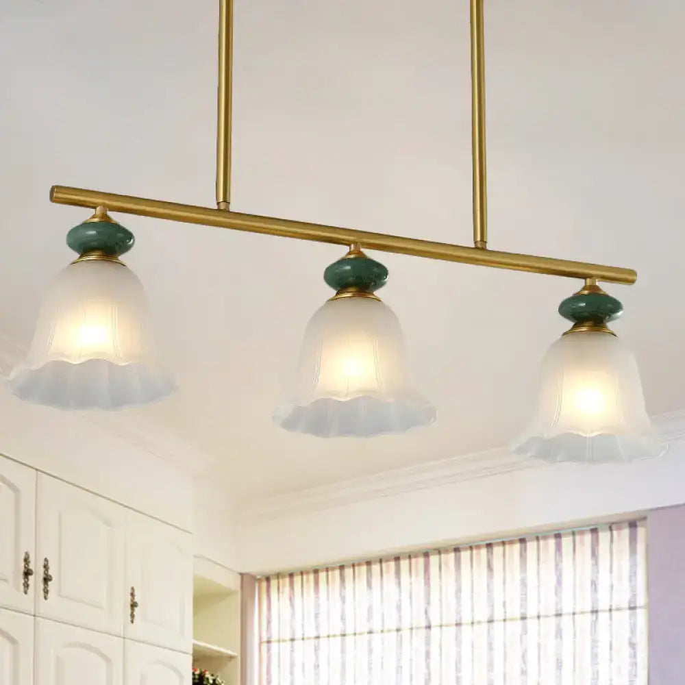 Traditional gold and teal kitchen island bar pendant light with cream glass shades and frosted glass accents