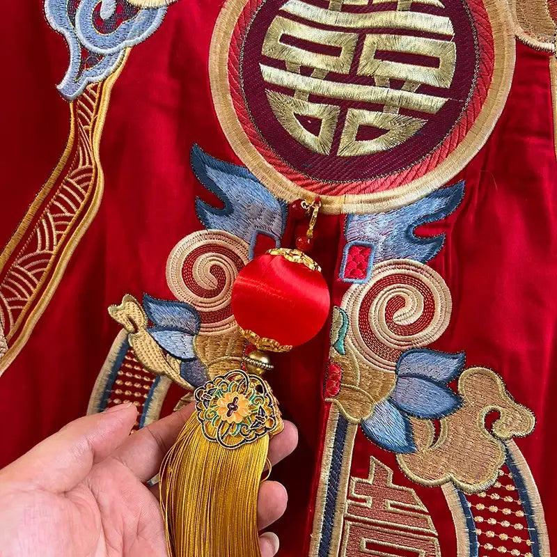 A vibrant red tassel ornament with gold metallic base and embroidered floral details for luxury gold loong bedding set decor