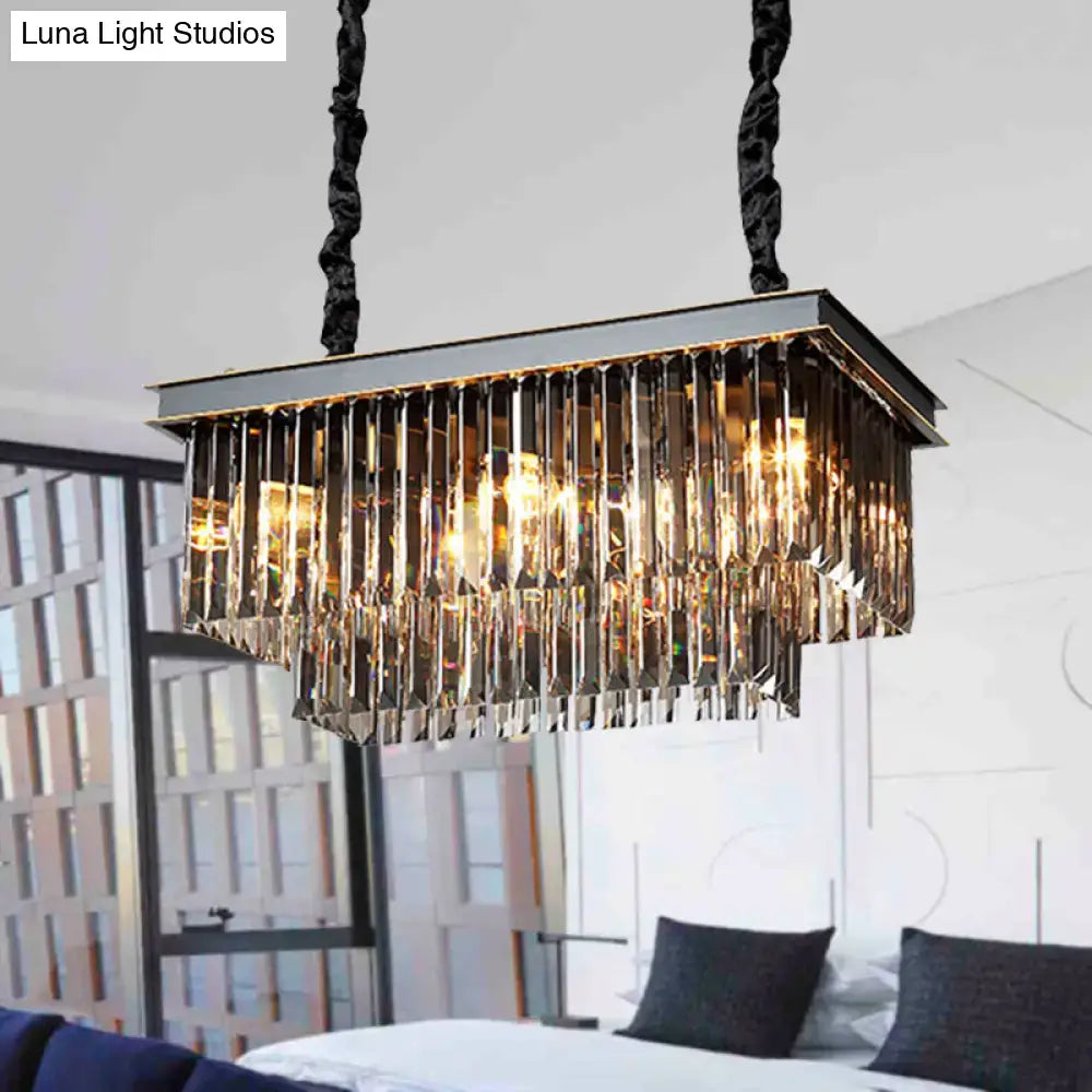 Rectangular dining room light fixture with smoke gray crystal blocks and a black metal frame with cascading prisms