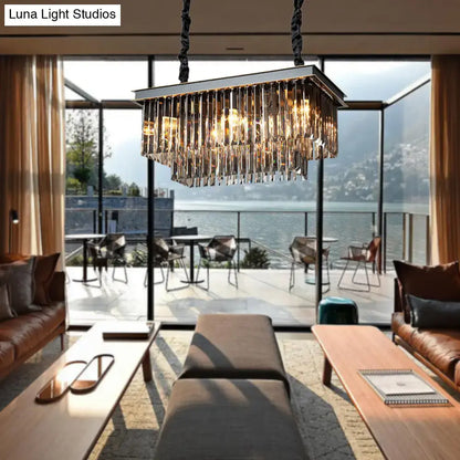A modern smoke gray light fixture with cascading crystal prisms and a metallic frame for dining room use