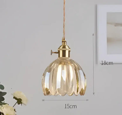 A golden faceted glass pendant light with brass fixture and twisted cord complementing decorbites blue glass pendant lights