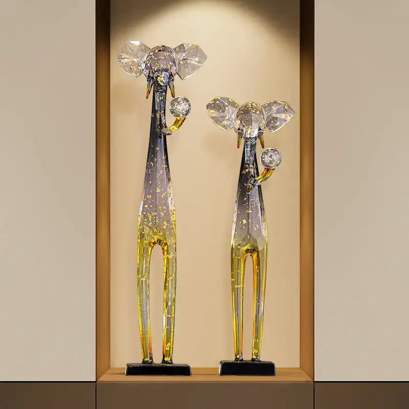 Two translucent glass elephant floor decoration figurines in blue to yellow gradient with crystal ears and gemstone trunks