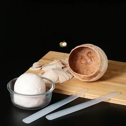 A translucent decorbites coconut opener tool with a hollowed-out brown coconut shell on a wooden cutting board