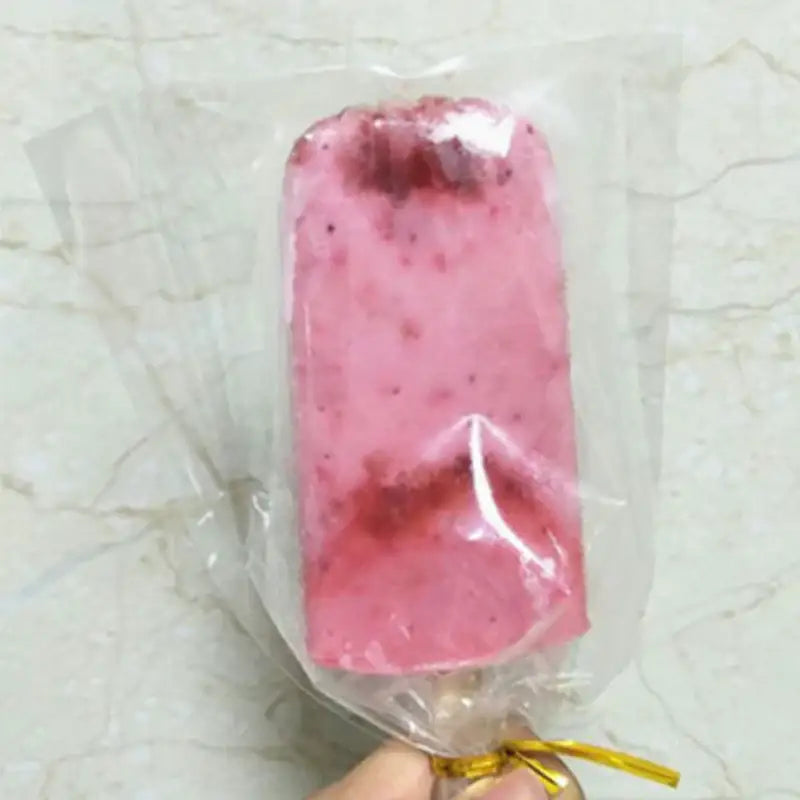 A pink berry flavored ice cream wrapped in transparent cream bags with gold ribbon for kitchen storage