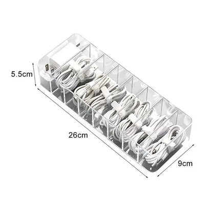 Transparent clear acrylic cable storage box with multiple compartments holding white charging cords by decorbites cable storage